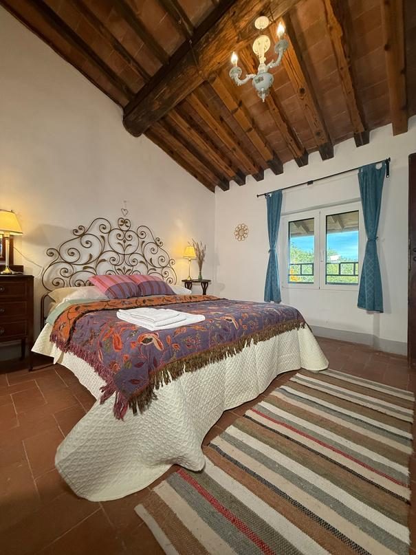 Bedroom with wooden beams and a wrought-iron bed